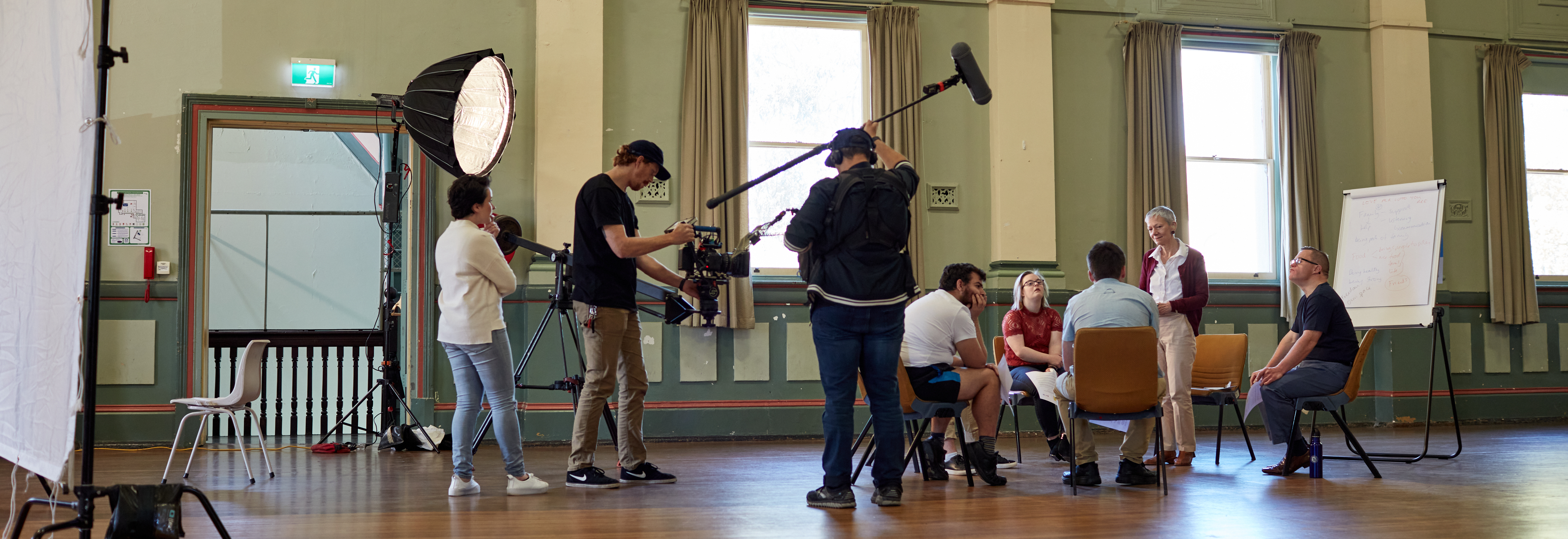 A film crew filming in a large university hall